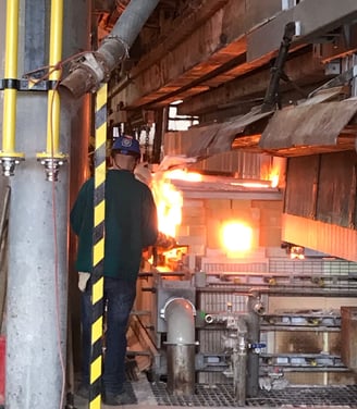 a man in a green shirt is standing in a factory