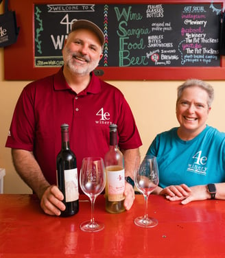 a man and woman standing in front of a bar