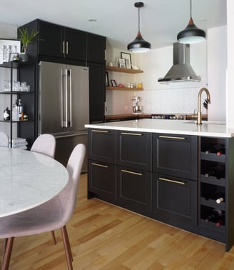 a black kitchen with a marble tulip table and chairs