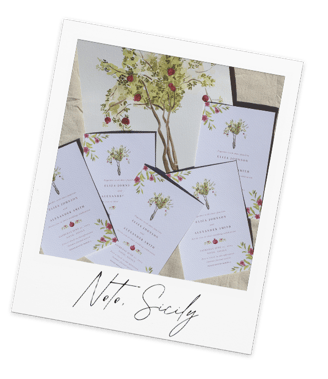 a bunch of wedding invitations with a pomegranate tree in the background