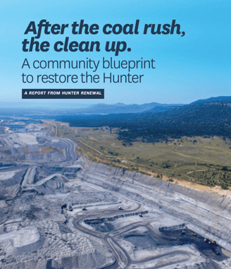 A large open cut coal mine with a blue sky and report title