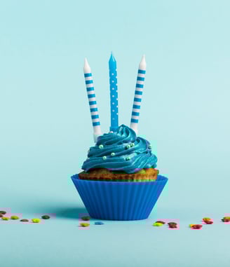 a cupcake with blue icing and candles