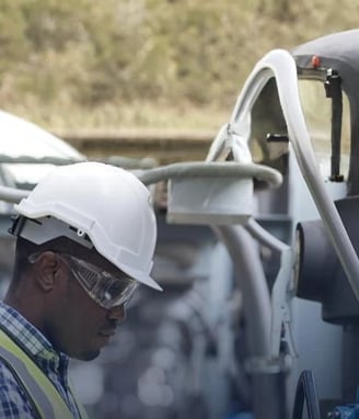 a man in a white helmet and safety glasses