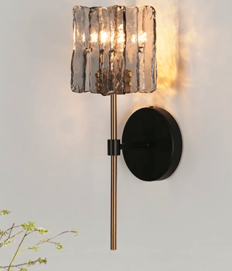 black and gold battery sconces on a neutral grey wall the light is moody and dark
