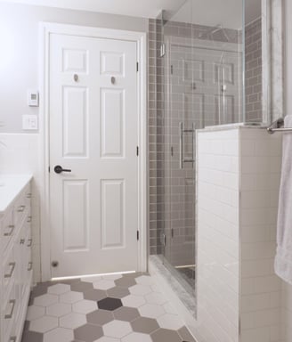 a bathroom with a shower and white vanity