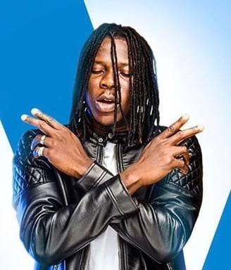 Stonebwoy in a black leather dress.