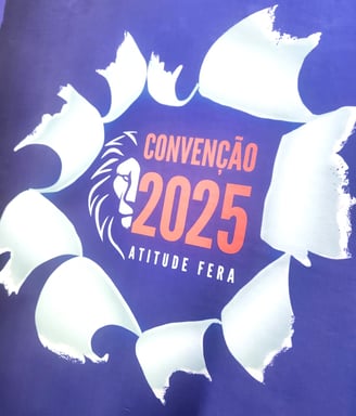 A imagem mostra uma camiseta promocional em sublimação, com um leão e convenção 2025