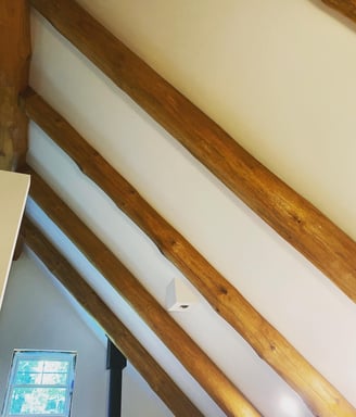 Finished drywall ceiling with exposed log beams