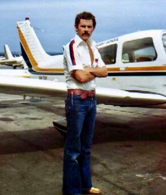 Peter Pickering stands in front of a Piper Cherokee in which he learnt to fly