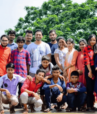a group of people standing in front of a tree
