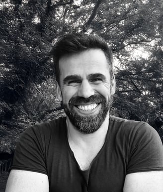 Adnan Erzen, Tai Ji and Qi Gong instructor at WDP Türkiye, smiling outdoors in a forest setting.