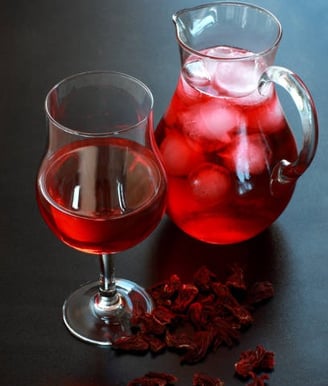 a pitcher of red wine with ice and a glass of wine