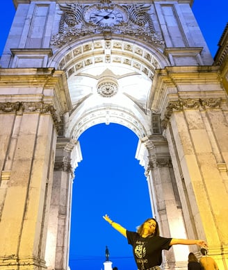 mulher em frente ao arco da rua Augusta em Lisboa Portugal