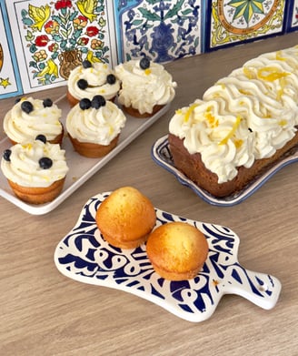 Cake au citron avec des cupcakes à la myrtille et crème chantilly.