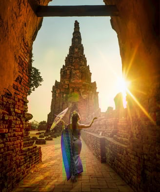 femme devant un temple qui porte une longue robe bleue et un parasol dans sa main