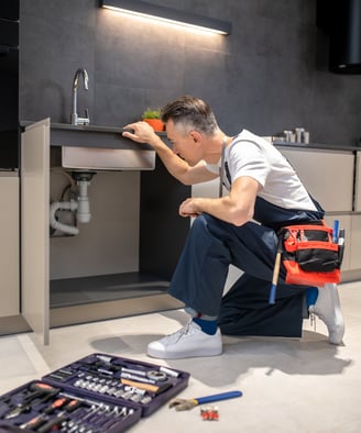 <a href="https://www.freepik.com/free-photo/man-kneeling-down-touching-sink-inspecting-pipes_2226482
