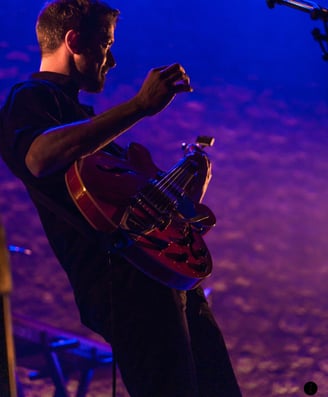 a man playing a guitar on stage