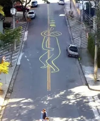 Intervenção Urbana: homem se segurando na faixa amarela da rua – Tec