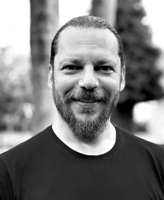 Alper Sümengen Tai Ji Qi Gong and sword instructor of WDP Turkey, smiling outdoors in black shirt