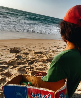 child sells instant noodles instead of playing in the sand.