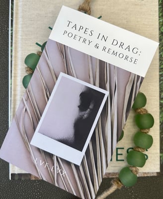 print book of tapes in drag: poetry & remorse by lvf.lvx on display with prayer beads