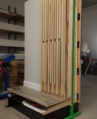 Interior wall mock-up with decorative wood slat paneling and raised flooring system for design and construction display
