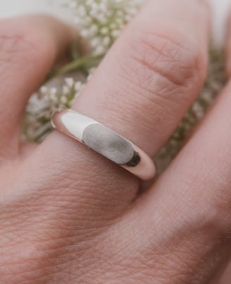 a person's hand holding a ring with a signetring on it
