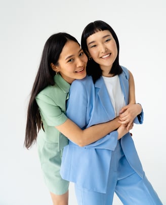 two women standing next to each other in a studio