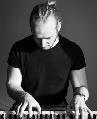 photo en noir et blanc d'un homme qui joue du piano