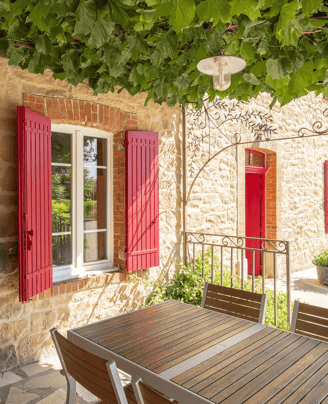 a table with a table and chairs in front of a stone building