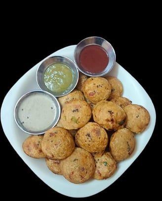 alt="Healthy Appes or Paniyaram served with coconut, spicy, and sweet sauces on a white plate"