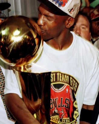 Michael Jordan kissing championship trophy in Bulls shirt