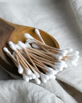 Bamboo cotton swabs in a wooden dish.