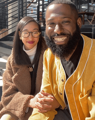 a man and woman sitting on stairs smiling