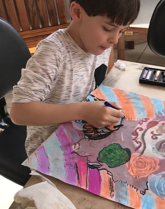 Crianças explorando cores em atividade de pintura artística.