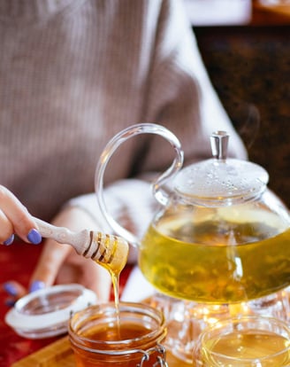 a person pouring tea into a teapot