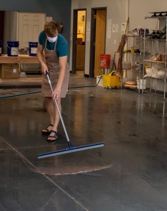 A student squeegeeing the floors of our clay studio.