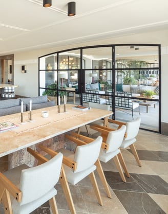Kitchen and dining area at Villa La Gratitud with stone table, designer chairs, and garden views.