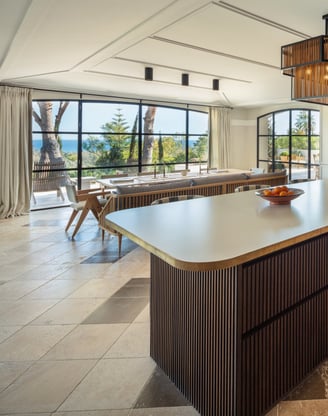 Contemporary kitchen at Villa La Gratitud with central island, designer lighting, and sea views.