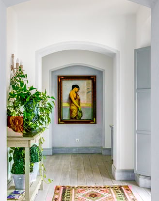 Hallway with flowers, paintings and rugs at Finca Santa Katerina