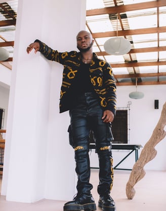 King Promise in a black shirt and black trousers.