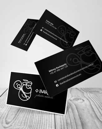 Cartões de visitas pretos com logo branco de produtora musical com homem barbudo segurando violão