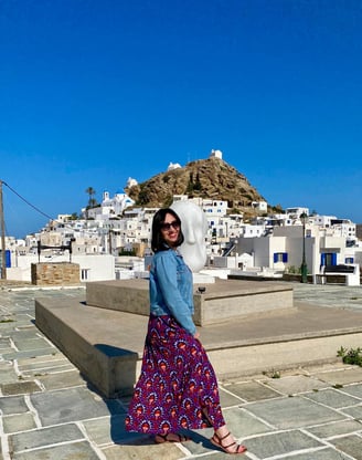 Une femme en robe devant un paysage de Grèce