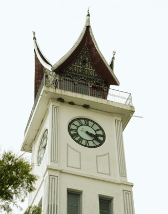 jam gadang, a clock tower with a clock on top of it