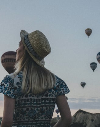 a woman in a hat and a straw hat is looking at a group of hot