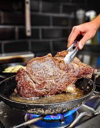 a person is cooking a steak steak on a pan