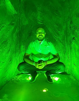 a man sitting in a tunnel with a green light