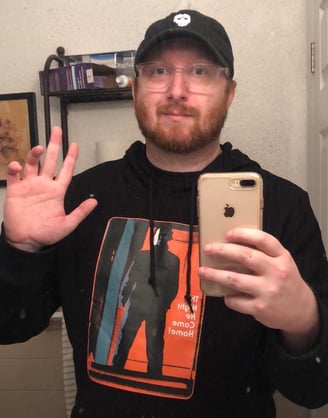 a man in a black hoodie and a phone