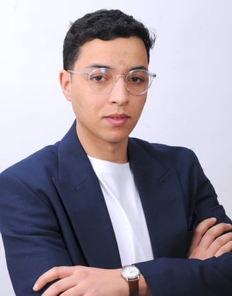 a man in a suit and glasses with a watch on his wrist