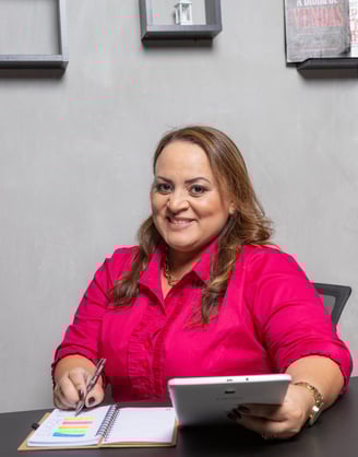 mulher com blusa pink sentada na cadeira do escritório falando sobre treinamento e desenvolvimento